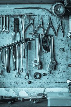 Old tools hanging on wall in workshop , Tool shelf against a wall