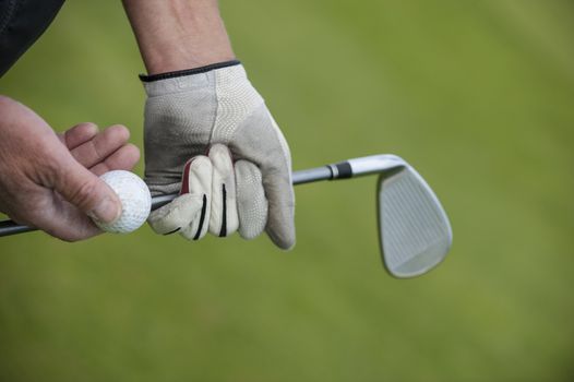 Golf club and ball in hand, France