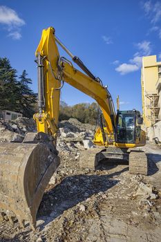 Yellow excavator with shovel  at construction site .