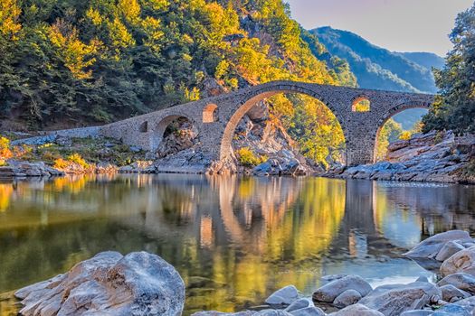 In autumn old stone bridge near Ardino, Bulgaria