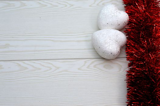 Red garland with two white hearts on wooden background