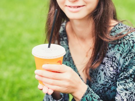 Woman hold cup of coffee on street. Paper cup with coffee in hands outdoors