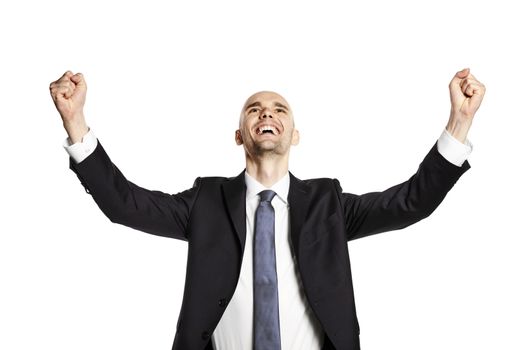 Studio shot of happy young man. He is looking up, gesturing by hands and celebrates victory.