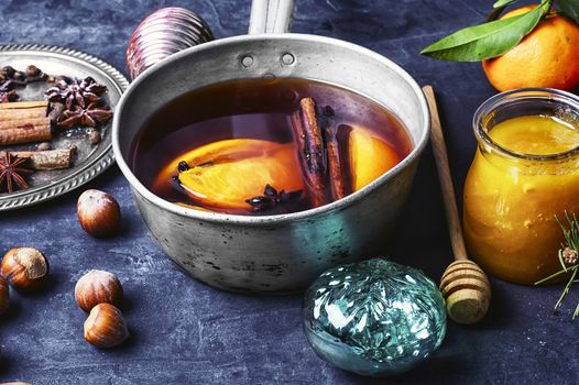 Hot wine with orange and spices set on dark slate background