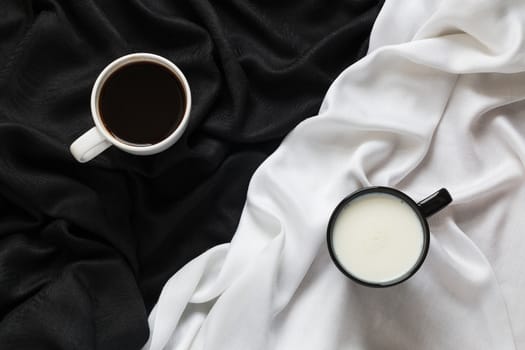 2 cups of coffee and milk on the black and white fabric. Top view