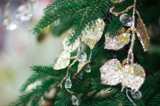 Christmas and New Year seasonal background of green tree with bright diamond drops and golden ornaments