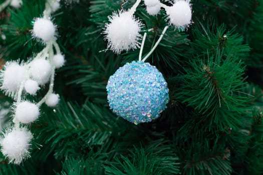 Christmas and New Year seasonal decoration, green tree branches with white snowy batch and blue ball ornaments