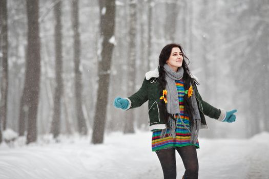 Beautiful young woman in a sweater on a winter walk in a park. Looking At Camera