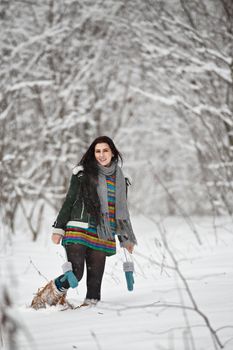 Beautiful young woman in a sweater on a winter walk in a forest. Looking At Camera