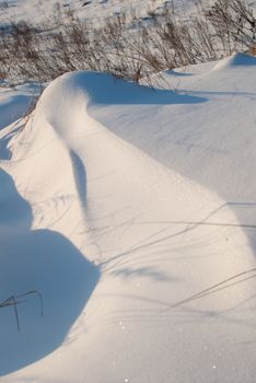 Beautiful winter landscape with snow-covered hills at sunset.