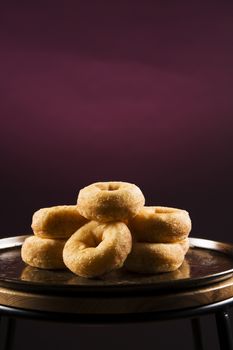 Fresh baked cinnamon donuts on a rustic metal baking tray.