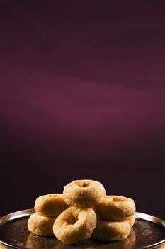 Fresh baked cinnamon donuts on a rustic metal baking tray.