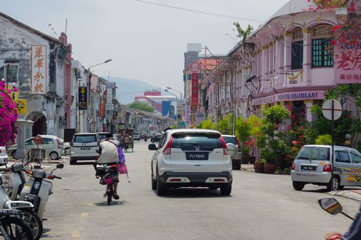 Georgetown, Penang, Malaysia - April 18, 2016 : few local people and cars walking driving around the street