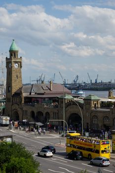 HAMBURG, GERMANY - JULY 18, 2016: a Beautiful view of famous Landungsbruecken with commercial harbor and Elbe river with blue sky and clouds in summer, St. Pauli district, Hamburg, Germany