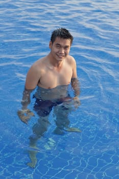 asian man standing in water pool