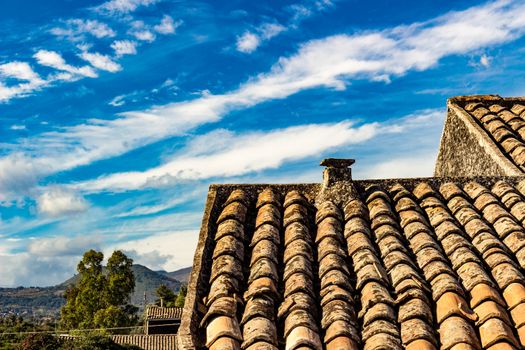 The ancient roof on a blue sky with clouds streaked