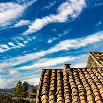 The ancient roof on a blue sky with clouds streaked