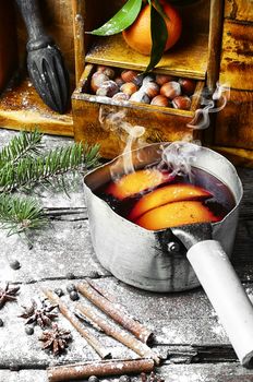 Warmed red wine in retro scoop with spices