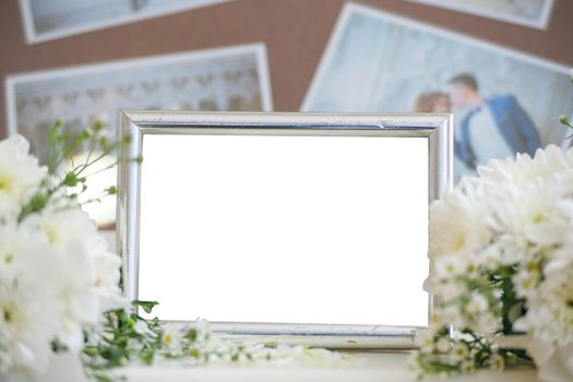 Blank vintage photo frame and flower on wooden background.