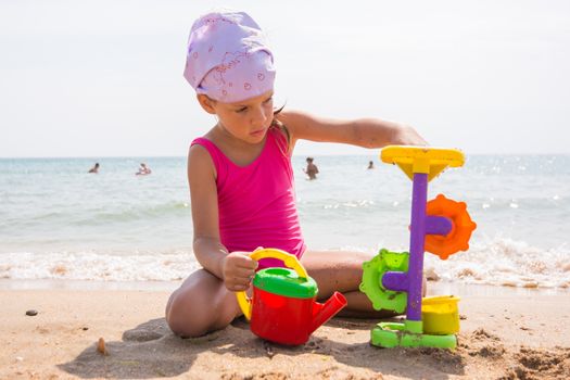 A child plays with toys in the sand on the beach