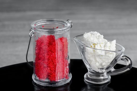 Red caviar and cream cheese in a glass container on the table and grey background. Selective focus.