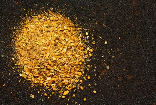 Pile of ground spices. Seasoning mix on a dark textured background. View from above. Image with copyspace.