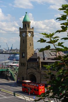 HAMBURG, GERMANY - JULY 18, 2016: a Beautiful view of famous Landungsbruecken with commercial harbor and Elbe river with blue sky and clouds in summer, St. Pauli district, Hamburg, Germany