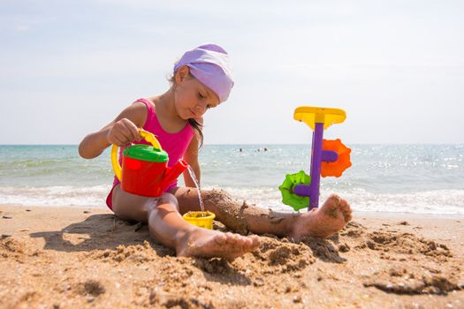 The girl in panama playing sand toys on the beach