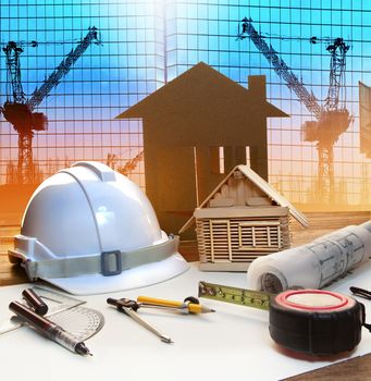 office tower and home construction plan on architect working table with modern building and crane background use for civil engineer and architectural backdrop scene 