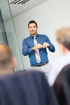 Businessman making a presentation at office. Business executive delivering a presentation to his colleagues during meeting or in-house business training, explaining new business concept and strategy.