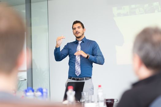 Businessman making a presentation at office. Business executive delivering a presentation to his colleagues during meeting or in-house business training, explaining new business concept and strategy.