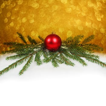 Christmas card with red bauble and snow on golden bokeh light background with copyspace