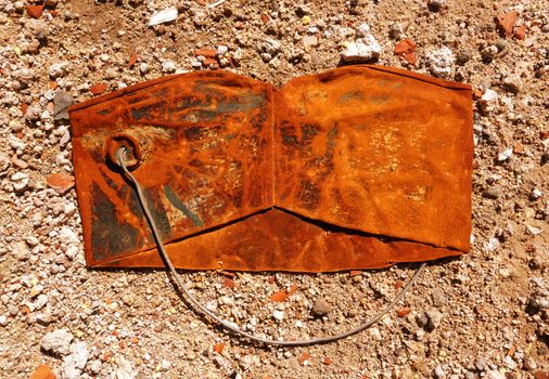 Old crushed rusty bucket on dusty background                               