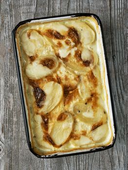 close up of rustic golden scalloped potato gratin dauphinois