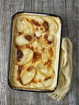 close up of rustic golden scalloped potato gratin dauphinois