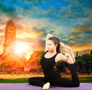 asian woman health care yoga posting with asian ancient pagoda temple and sun set sky