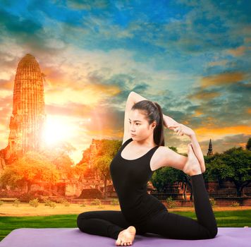asian woman health care yoga posting with asian ancient pagoda temple and sun set sky