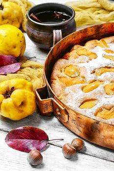 Baked pie with quince in copper kitchen form
