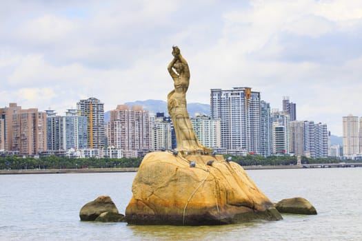  Zhuhai Fisher Girl sculpture important landmark of visitor when visited to  zhuhai city china against residence building background 