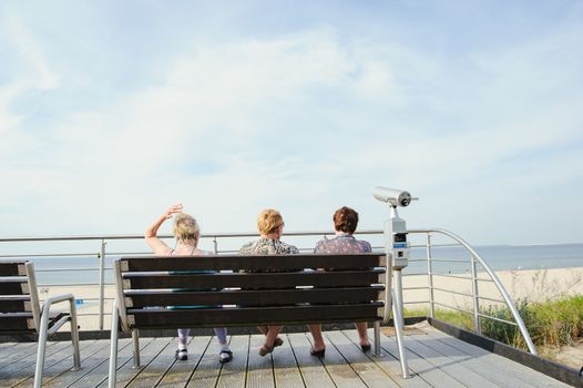 tourists sit on a bench at the beach