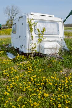 Old forgotten Travel trailer camping in spring