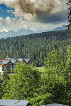 Guest house in the traditional mountain style and mountain landscape. View of cottage from wooden. Tatra mountains. Poland. Copy space. Summer trave