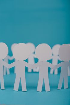 abstract paper people holding for hands on blue background