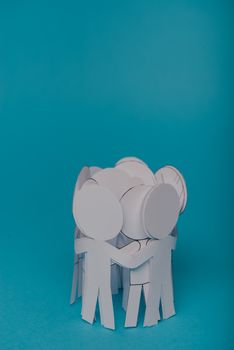 abstract paper people holding for hands on blue background