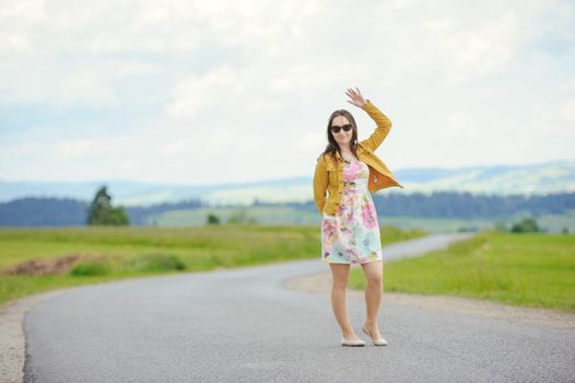 girl standing on asphalt country road in the mountains