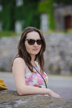 Beautiful brunette young woman wearing dress and walking on the street