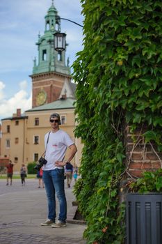 Male tourist takes picture in historic city in Cracow, Poland.