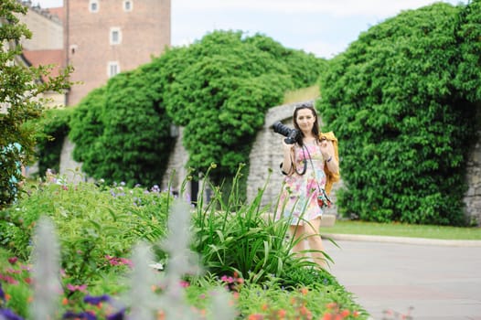 Female tourist takes picture in historic city in Cracow, Poland.