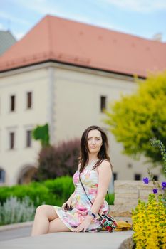 Beautiful brunette young woman wearing dress and walking on the street
