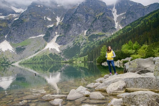 woman relaxing on the lake and mountains sunny landscape.